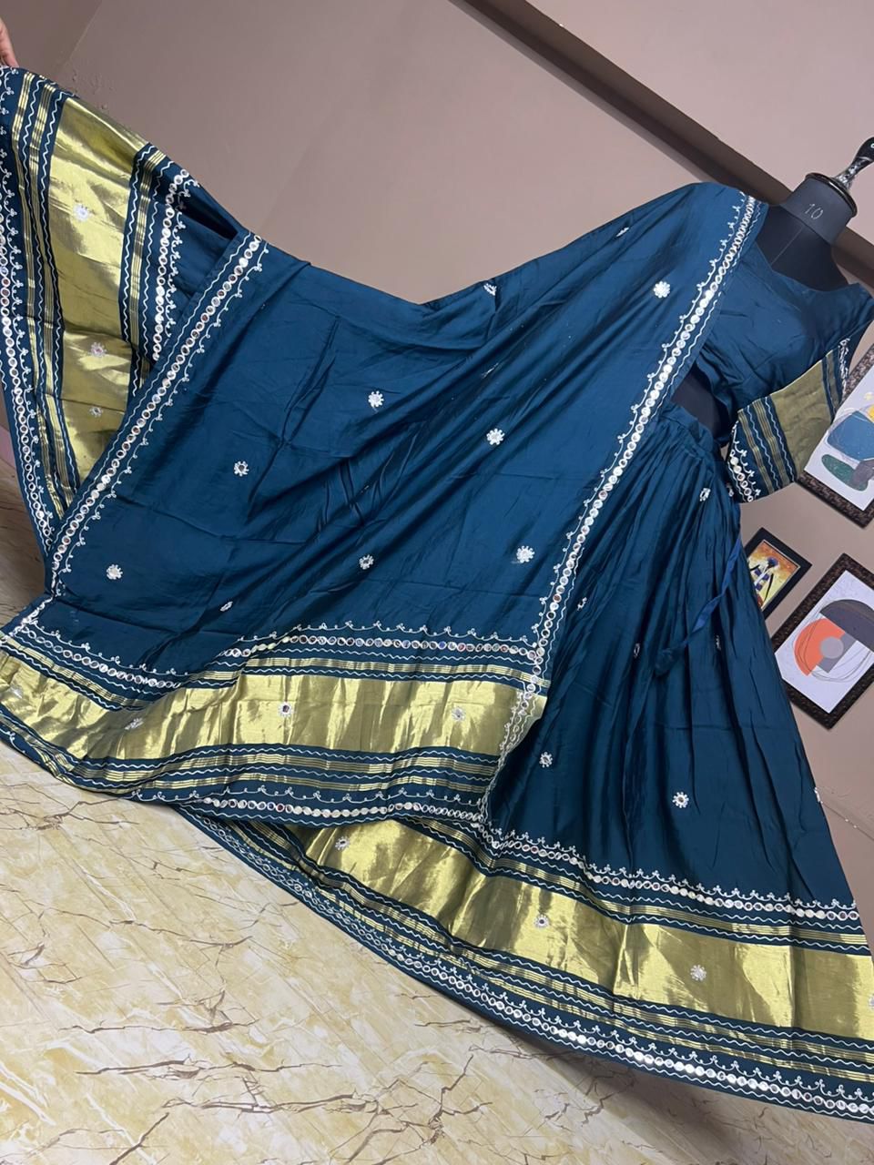 Blue and yellow saree with intricate patterns on a marble surface