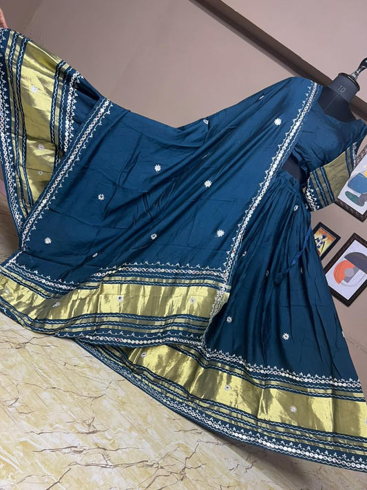 Blue and yellow saree with intricate patterns on a marble surface