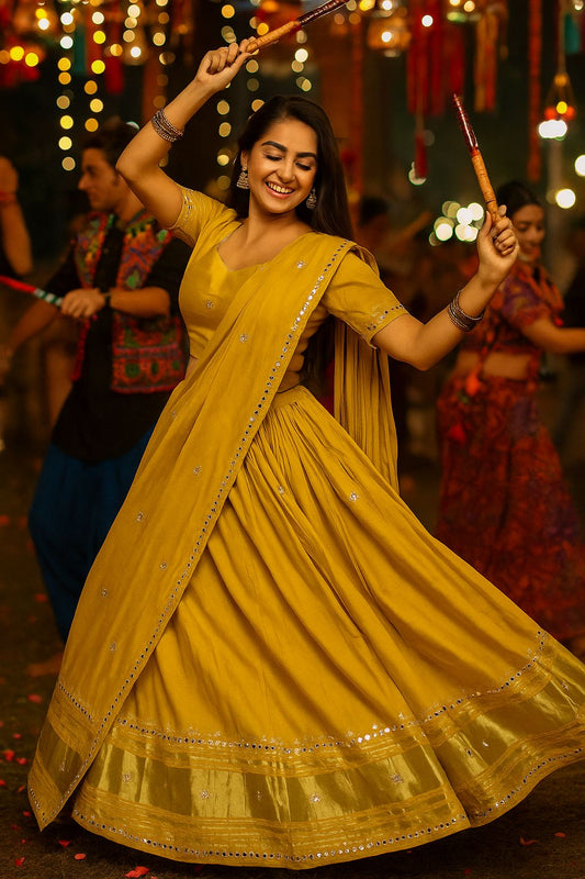 Woman in a yellow saree dancing with lights in the background